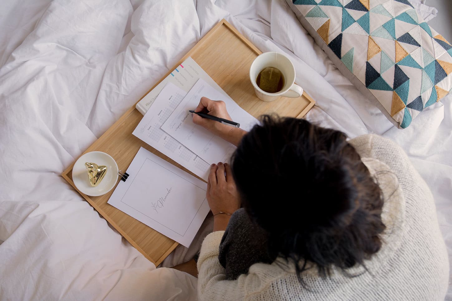 woman doing writing notes in bed representing comfortable lifestyle of living at The Groves Lithonia apartments for rent in lithonia GA